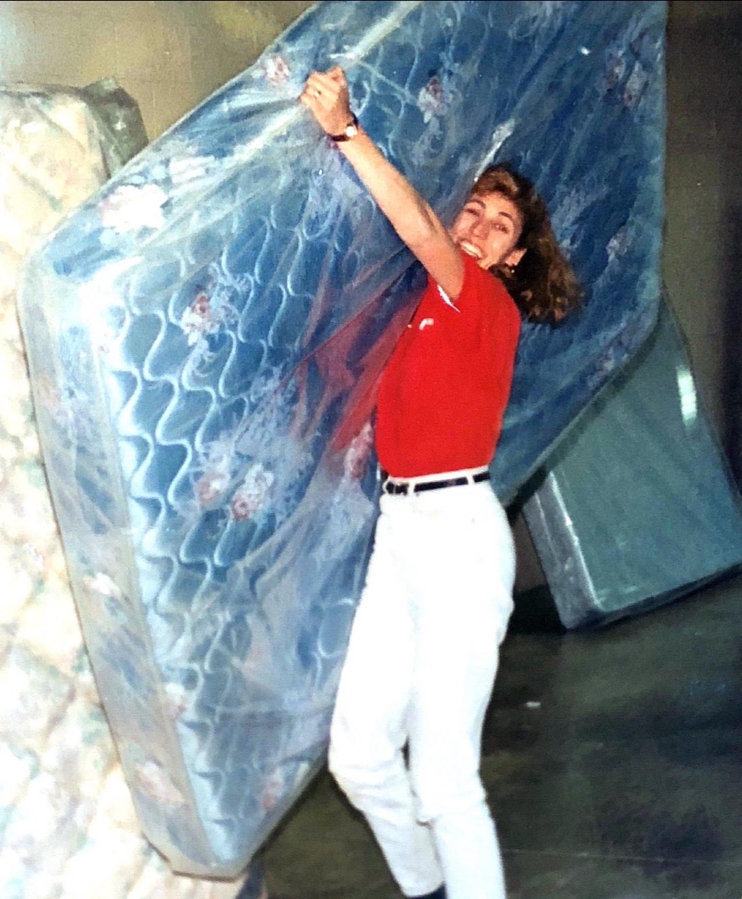 Sherrie Bower helping a customer with a mattress in an early showroom