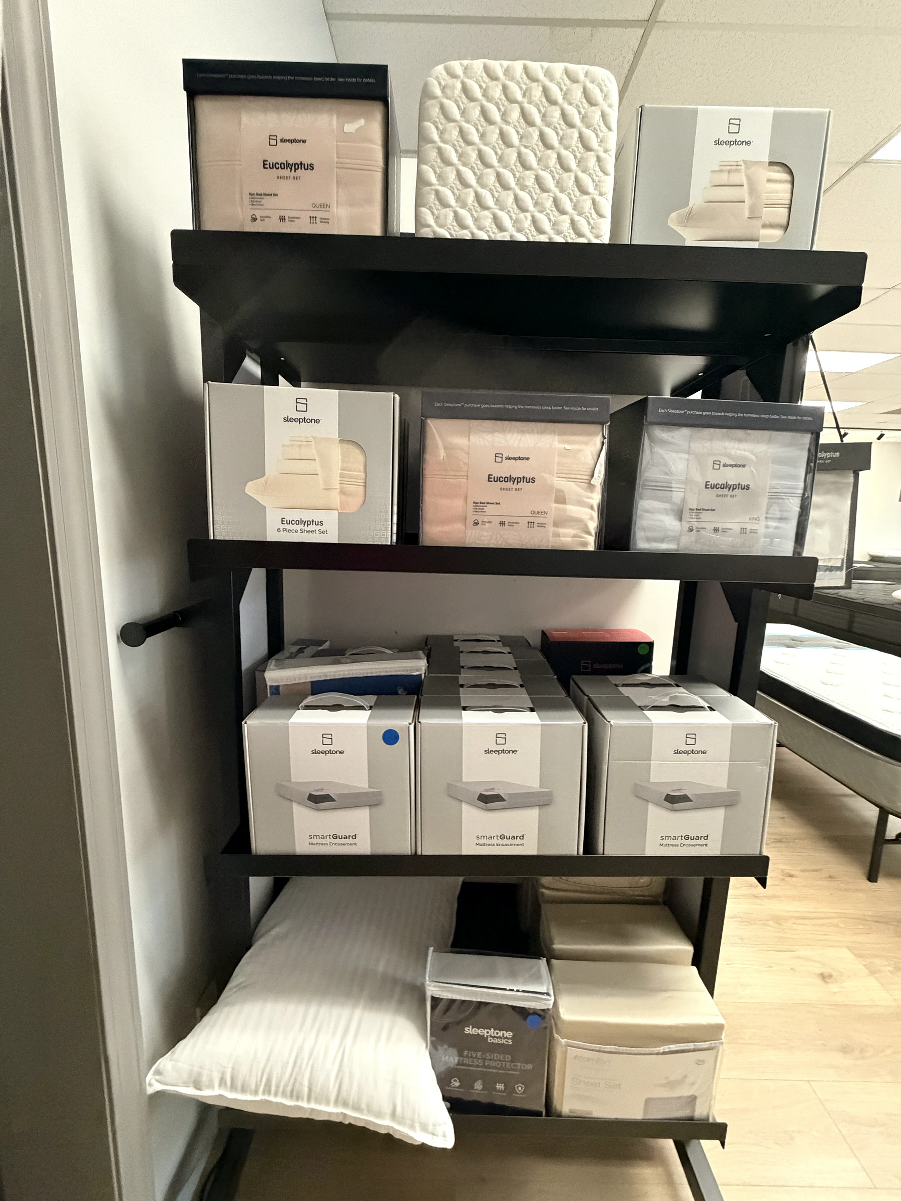 Sleeptone sheets, protectors, and bedding on display inside Mack Mattress